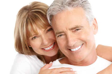 An older man and woman hugging and smiling about their pocket reduction procedure from Martin Periodontics 
